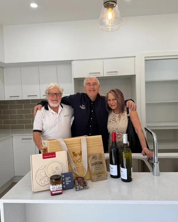 Residents Neil and Carol in the kitchen of their new home with Vic Sabados